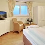 Bedroom with bed, TV, chair, and window.