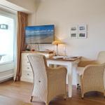 Dining room with table, two chairs, and TV. Access to terrace.