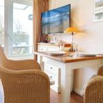 Dining area with table, chairs, and TV. Window to terrace.
