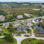 Houses with roofs and green areas in a rural setting.