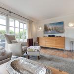 Living room with fireplace, seating, and large window view.