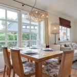 Dining room with table, chairs, and garden view. Living area with sofa and coffee table.