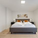 Bedroom with double bed, two nightstands, and wall mirror.