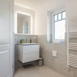 Bathroom with sink, mirror, and window.
