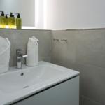 Badezimmer mit Waschbecken, Spiegel und Handtüchern