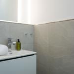 Bad mit Waschbecken, Spiegel und Handtuch