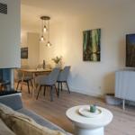 Wohnzimmer mit Kamin, Esstisch und Fernseher.