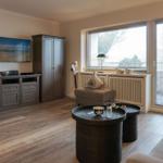 Wohnzimmer mit TV, Schränken und Fenster mit Jalousien.