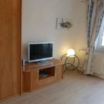 Das Wohnzimmer, mit Farbfernseher , Bücher und Schrank, gegenüber die Couch