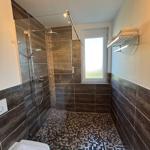 Dusche mit Glaswand, Mosaikwand und Fenster