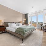 Bedroom with bed, nightstand, and view of balcony.