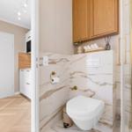Bathroom with marble wall, toilet, and shower