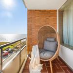 Balcony with wicker chair and sea view