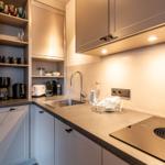 Kitchen with sink, cooktop, and dish racks.