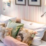 Bed head with pillows and wall lamps on striped wall