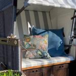 Hanging chair with striped cover and cushions in the garden.