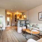 Living area with sofa, coffee table, and view into the kitchen.