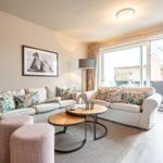 Living room with two sofas, round tables, and view to the terrace.