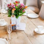 Holztisch mit Tischdekoration und Blumenstrauß