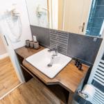 Waschbecken mit Spiegel, Handtuchwärmer und Toilettenpapier