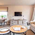 Wohnzimmer mit Sofa, Couchtisch und Fernseher an der Wand.