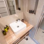 Badezimmer mit Waschbecken, Dusche und Flaschen