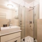 Badezimmer mit Dusche, Waschbecken und Spiegel.