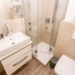 Badezimmer mit Dusche, Waschbecken und Toilette.