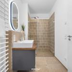 Bathroom with shower, sink, and heated towel rack.