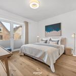 Bedroom with bed, desk, and window to balcony.