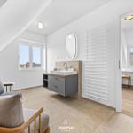 Bedroom with sloped ceiling, bathroom, and seating area