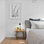 Bedroom with bed, nightstand, and wall art.