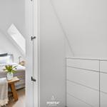 Bedroom with sloped ceiling, bed, nightstand, and closet