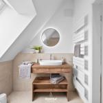 Bathroom with sloped ceiling, sink, and radiator