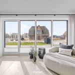 Living room with large window view of rooftops and green areas.