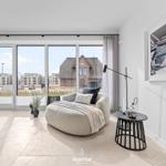 A room with large windows, seating, and wall art.