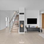 Living area with fireplace, TV, and staircase to upper level.