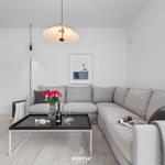 Living room with gray sofa, black coffee table, and hanging lamp.