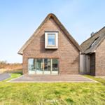 House with thatched roof and glass facade