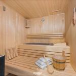 Sauna mit Holzbank, Waschbecken und Handtuch.