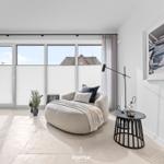 Wohnraum mit Sessel, Tisch und Fenster zur Aussicht.