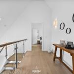 Hausflur mit Holzboden, Treppe und Wandspiegel