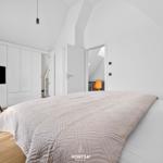 Bedroom with bed, TV, and sloped ceiling
