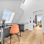 Attic with desk, orange chair, and view of the roof