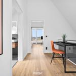 Bedroom with sea view and work desk with orange chair.