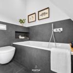 Bathroom with bathtub, toilet, and wall pictures
