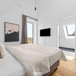 Bedroom with bed, window, wall art, and TV.