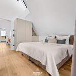 Bedroom with bed, wardrobe, and view of terrace.