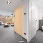 Hallway with bathroom and access to lounge with seating.