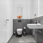 Modern bathroom with sink, toilet, and mirror